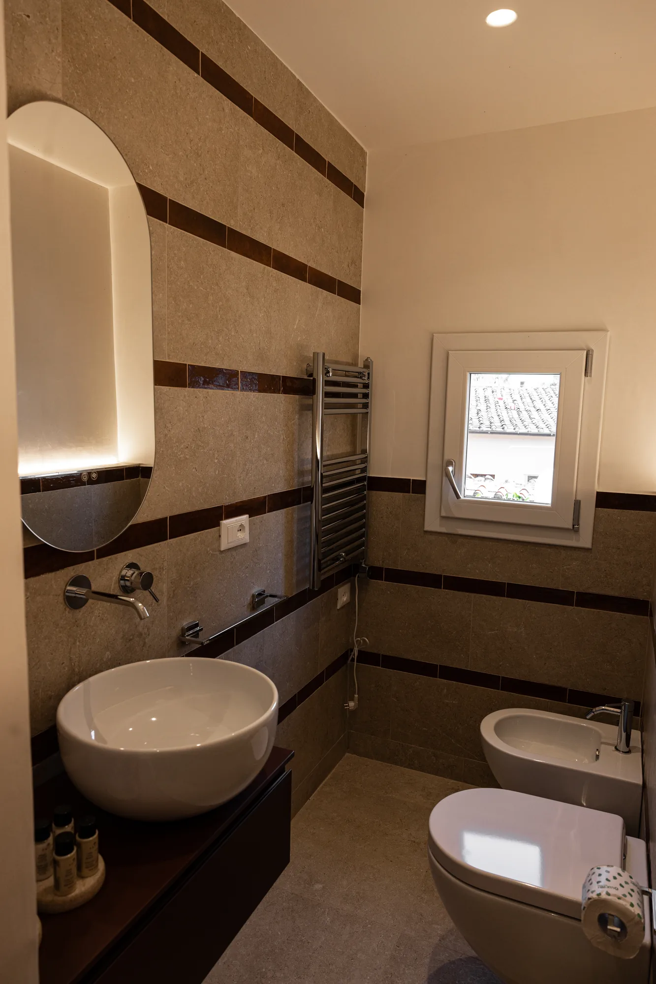 Bathroom with bowl sink, bidet, toilet, and window