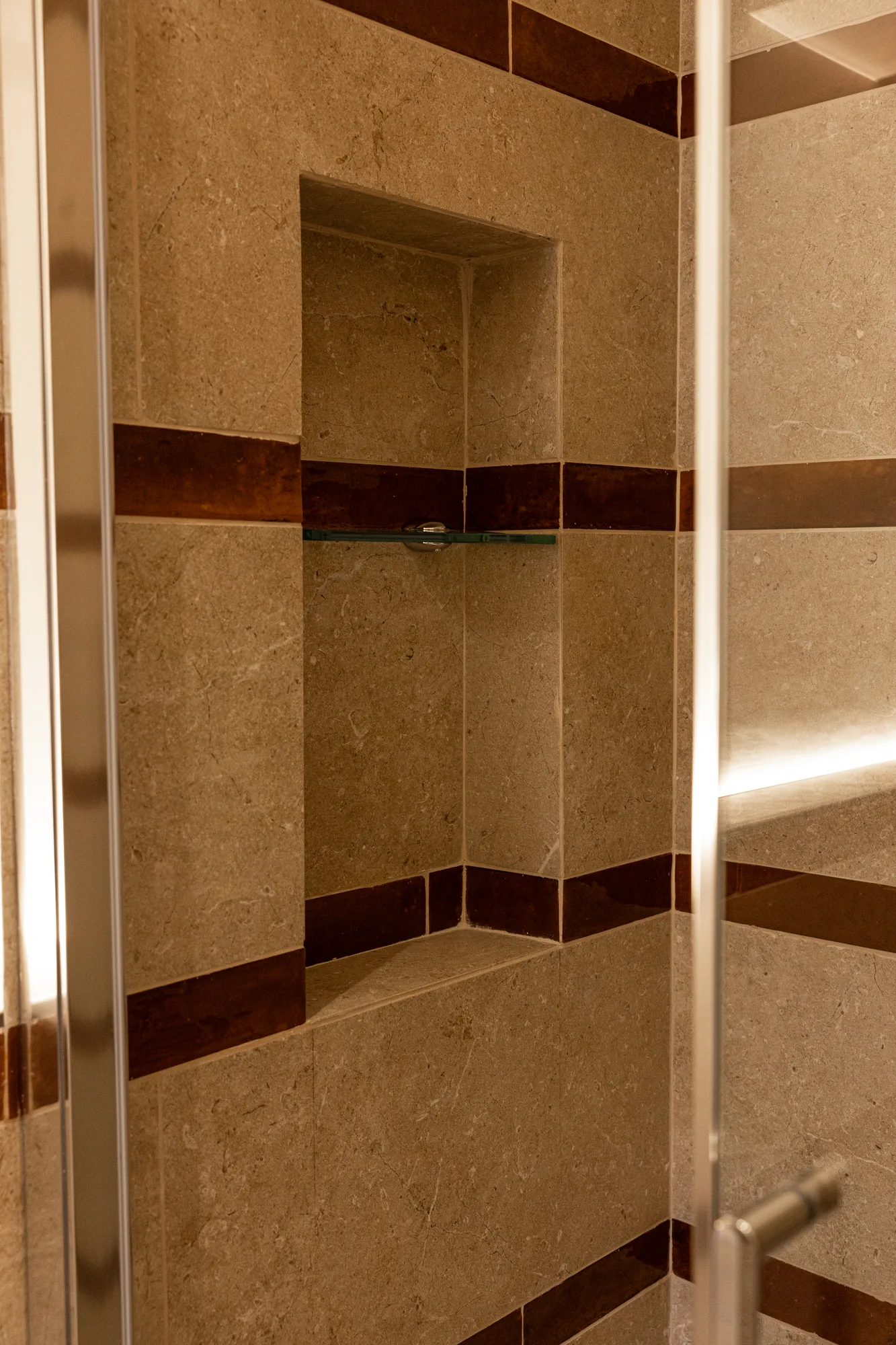 Stone shower with niche and glass shelf