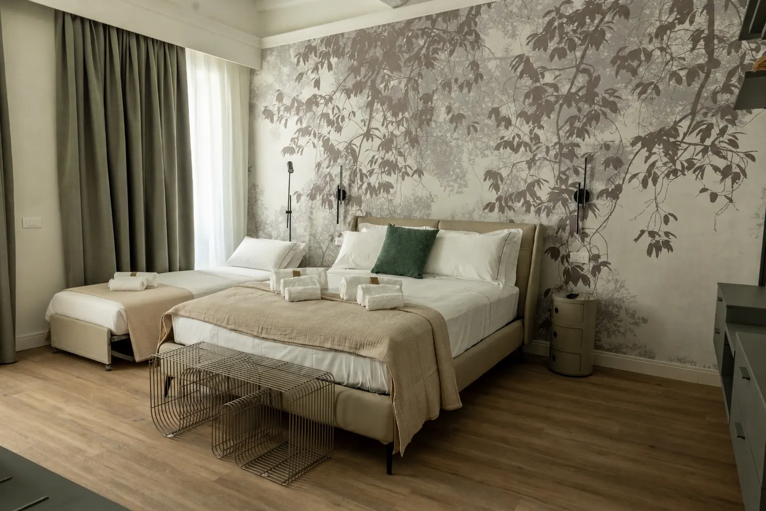 Camera da letto moderna con due letti, decorata con carta da parati floreale e tende grigie