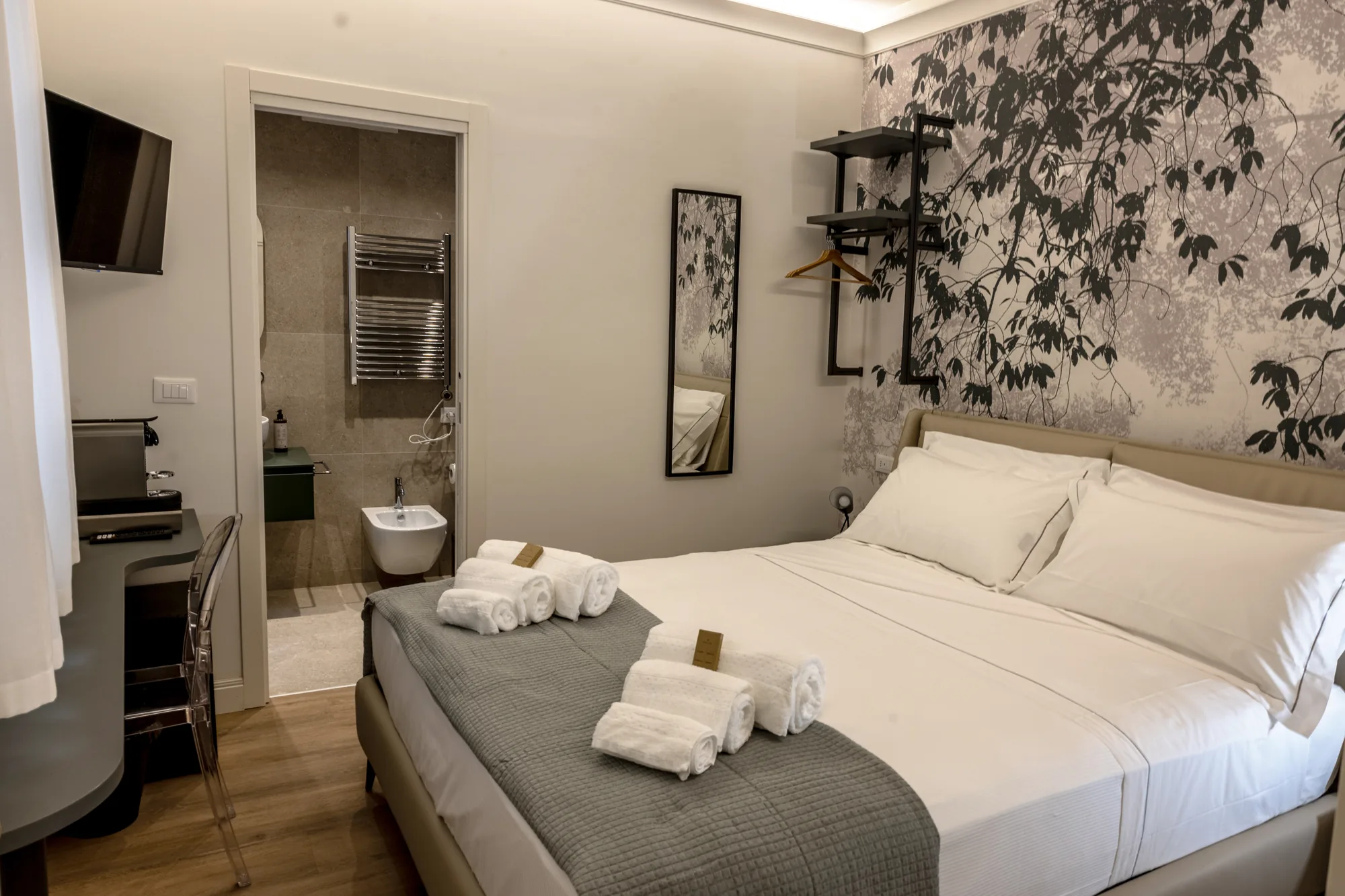 Camera d’hotel con letto matrimoniale, bagno a vista e scrivania