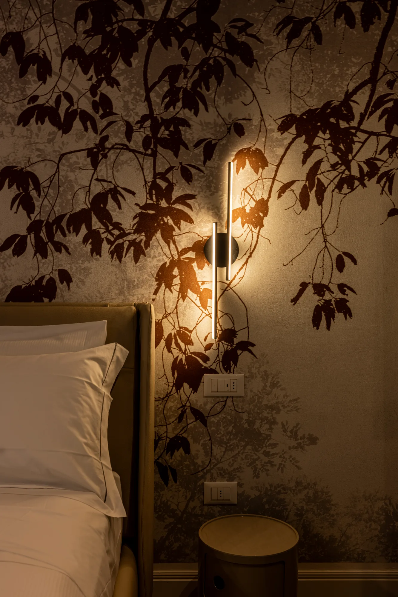 Bedroom with LED wall lamp, headboard, and wallpaper with leaf pattern
